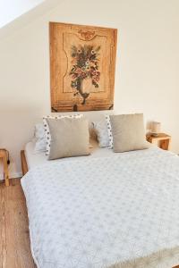a bed with two pillows and a painting on the wall at Apartmán NEWSTALGIE in Mikulov
