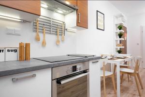 a kitchen with a counter and a table with a dining room at Business Kasprzaka Serviced Apartments P&O in Warsaw