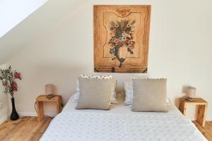 a bedroom with a white bed with pillows and a painting at Apartmán NEWSTALGIE in Mikulov