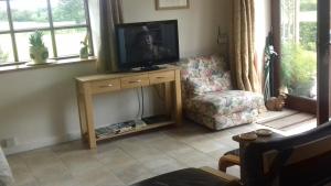 a living room with a television on a wooden stand at Harris End in Lancaster