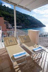 - deux chaises et des tables sur un balcon donnant sur l'eau dans l'établissement Taverna Del Capitano, à Massa Lubrense