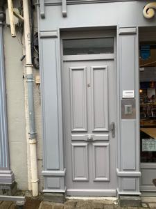 a gray door on a building next to a store at nuit sur le pont 5 in Landerneau