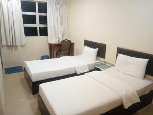 Un pat sau paturi într-o cameră la MELINTANG HOTEL SDN BHD