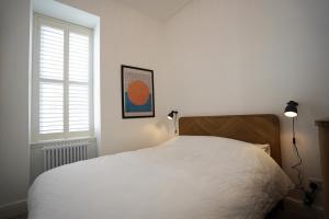 a bedroom with a white bed and a window at Beach house no2 with amazing sea views and private garden onto beach. in Fairlie