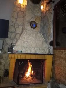 a stone fireplace with a fire in it at To Konaki in Synikia Mesi Trikalon