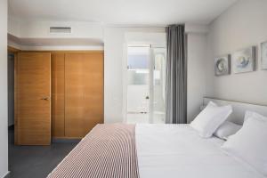 - une chambre avec un grand lit blanc et une porte dans l'établissement Stancia Carmen, à Valence