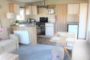 een kleine keuken en een woonkamer met een tafel bij Newquay Bay Resort - Spacious - Sleeps 6 - Close to Porth Beach in Newquay