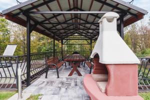een paviljoen met een picknicktafel en banken bij Apartament Neapol Rezydencja Sienkiewicza by Renters in Zakopane