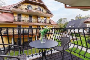 a patio with a table and chairs and a building at Apartament Neapol Rezydencja Sienkiewicza by Noclegi Renters in Zakopane