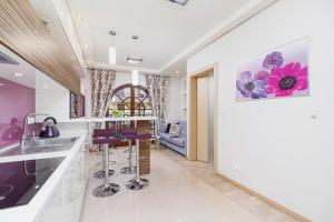 a kitchen and living room with purple accents at Apartament Neapol Rezydencja Sienkiewicza by Noclegi Renters in Zakopane