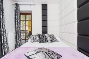 a bedroom with a bed with black and white pillows at Apartament Neapol Rezydencja Sienkiewicza by Noclegi Renters in Zakopane +38 photos