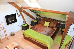 a bedroom with a bed with a green blanket at Maison d'hôtes Zen in Arbin