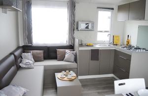 ein kleines Wohnzimmer mit einem Sofa und einer Küche in der Unterkunft Camping Club Le Trianon - Maeva in Olonne-sur-Mer