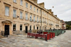 a row of red benches in front of a building at Hotel Indigo - Bath, an IHG Hotel in Bath