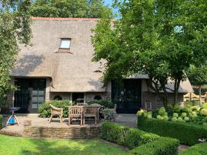a house with a table and chairs in the yard at Hofstede "Den Hul"- Riant & Authentiek onthaasten - 8 persoons in Barneveld
