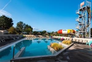 a pool at a resort with chairs and a water slide at Camping Club Le Littoral - Maeva in Argelès-sur-Mer