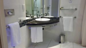 a bathroom with a sink, mirror, and towel rack at Holiday Inn Express Cape Town City Centre, an IHG Hotel in Cape Town
