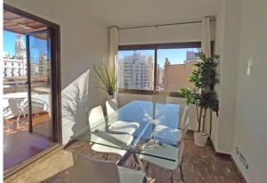 a glass table and chairs in a room with a window at Sunny apartment with fantastic terrace views! in Valencia