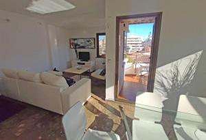 a living room with white furniture and a large window at Sunny apartment with fantastic terrace views! in Valencia