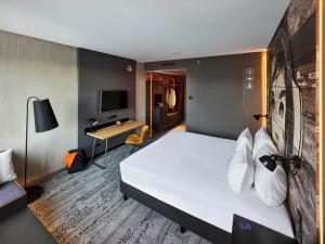 a hotel room with a bed and a desk at Jaz in the City Amsterdam in Amsterdam