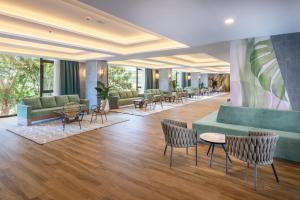 un vestíbulo con sofás, mesas y sillas en Hotel Riu Buenavista - All Inclusive, en Adeje