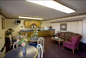 sala de estar con sofá, mesa y sillas en America's Best Value Inn Litchfield, en Litchfield