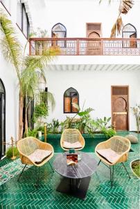 un patio con tavolo, sedie e piscina di Riad Dar Yasaman a Marrakech