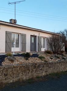a small house with a stone wall in front of it at Au Coeur du Bocage Vendéen in Chantonnay