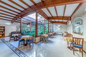 comedor con mesas y sillas y ventanas grandes en Hotel Le Torri, en Arborea 