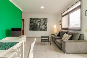 sala de estar con sofá y pared verde en Nice Canteras - 2BDR + WiFi + Balcony en Las Palmas de Gran Canaria