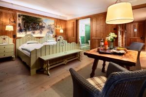 a bedroom with a bed and a table and chairs at Post Lech Arlberg in Lech am Arlberg