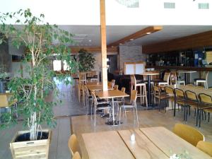 a restaurant with wooden tables and chairs and plants at Värdshuset Flottaren in Vansbro