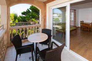 een veranda met een tafel en stoelen op een balkon bij Apartamentos Quijote Park in Cala Ratjada