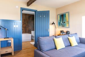 a living room with a blue couch and a bathroom at The Seagate in Appledore