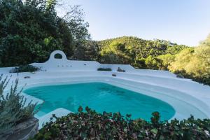 a swimming pool in the middle of a hill with blue water at Hotel Humaina in Málaga