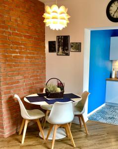 a dining room with a brick wall and a table and chairs at Apartament „Arctic Blue” in Jelenia Góra