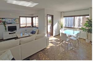 a living room with a white couch and a table at Sunny apartment with fantastic terrace views! in Valencia