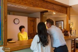 een man en een vrouw die aan een balie staan bij Gardenvilla Shirahama in Shimoda