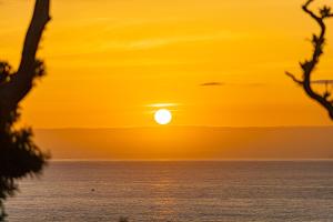 a sunset over the ocean with the sun setting at Gardenvilla Shirahama in Shimoda