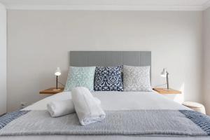 a bedroom with a large bed with blue and white pillows at Stunning Views, the Sea & Table Mountain! in Bloubergstrand