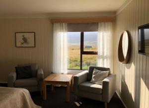 a room with a bed and a chair and a window at Hotel Raudaskrida in Þóroddsstaður