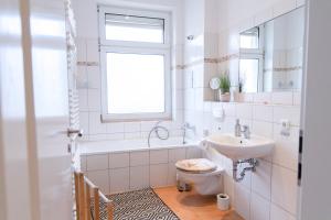ein weißes Bad mit einem Waschbecken und einem WC in der Unterkunft Blue Chili 01 - TOP City Lage am HBhf Boxspringbett bis 4 Pers in Magdeburg