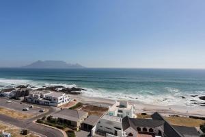 an aerial view of a beach with houses and the ocean at Stunning Views, the Sea & Table Mountain! in Bloubergstrand