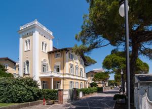 a large building with a tower on a street at Residence Villa Marina in Grado