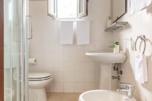een witte badkamer met een toilet en een wastafel bij Happy Sea Home - monolocale sul mare con piscina in Albinia