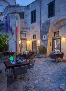 um restaurante com mesas e cadeiras em frente a um edifício em Residence San Pietro Barisano em Matera