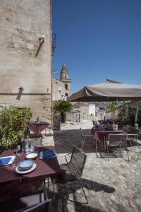 
a restaurant with tables and chairs in front of it at Residence San Pietro Barisano in Matera
