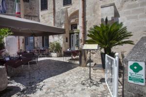 
a patio area with tables, chairs and umbrellas at Residence San Pietro Barisano in Matera
