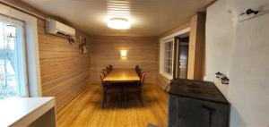 a dining room with a wooden table and chairs at Hideaway Cottage in Ivalo +19 photos