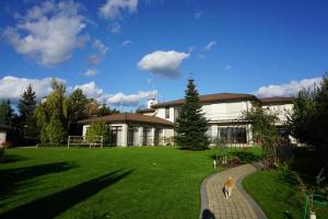 a house with a dog standing in front of a yard at Great accommodation for rest and relaxation! in Vishenki